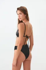 Bombacha tipo vedetina de tiro alto, color negro, confeccionada en tejido elástico con acabado satinado. Presenta una etiqueta de la marca CaroCuore en el centro de la cintura posterior.