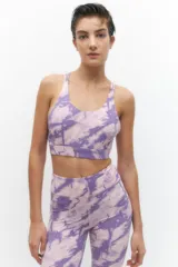 Top de yoga sin mangas, color lila, con straps cruzados en la espalda.