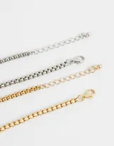 Set de dos pulseras flexibles con cadena de eslabones cuadrados, una plateada y otra dorada.