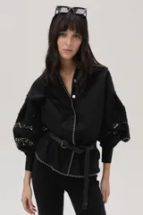Camisa negra de popelina con calce recto y mangas abullonadas con galones de encaje floral. Incluye cinturón fino con hebilla metálica.