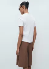 Camiseta blanca de algodón, de corte recto, manga corta y cuello redondo.