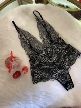 Body entallado de encaje bitono negro con detalles en color hueso, breteles regulables y escote pronunciado. El encaje es suave y elastizado.