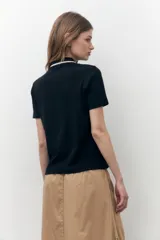 Remera de algodón color beige, con cuello polo y cierre frontal, de manga corta.