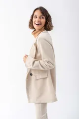 Blazer color beige de pana con solapas de muesca, cierre frontal con un botón, bolsillo de parche y corte holgado.