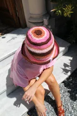Gorro tipo bucket tejido al crochet con diseño a rayas horizontales en tonos marrón, rosa y beige.