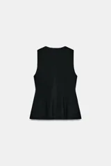 Top de punto acanalado en color beige, sin mangas y con cuello redondo. Presenta un cierre frontal con botones pequeños y un bajo con acabado en peplum que aporta volumen.