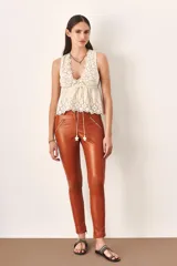 Pantalón legging de cuero color marrón con cierre en los bolsillos.
