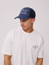 Gorra azul marino con visera, de lona de algodón y malla trasera. Estampado frontal con el logo de la marca Rusty.