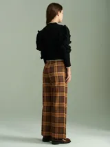 Cardigan marrón de tejido de punto con cierre frontal, cuello redondo y mangas abullonadas con apliques de pompones.