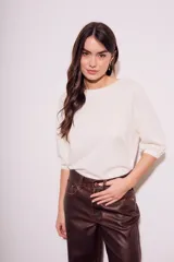 Remera color crema de algodón peinado, con mangas 3/4 abullonadas y corte ajustado al cuerpo.
