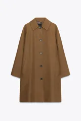Trench color marrón confeccionado en mezcla de algodón. Cuello solapa, manga larga con trabillas y botón, bolsillos delanteros y cierre frontal con botones.