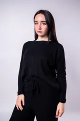 Buzo de punto color negro, con cuello redondo y lazo ajustable en la cintura.