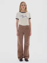 Jean wide leg color marrón con estampado de rombos en tonos beige y azul. Incluye un cinturón integrado en la pretina con hebilla metálica.
