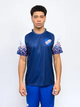 Remera de entrenamiento azul con detalles blancos en hombros y mangas, escudo del Club Nacional de Football en el pecho.
