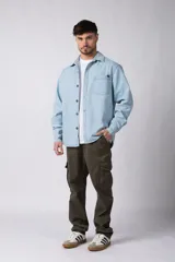 Chaqueta de jean celeste de corte recto, con cuello clásico, cierre frontal con botones metálicos y bolsillo de parche en el pecho.