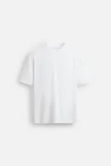 Camiseta blanca de algodón de peso medio, corte slim fit, cuello redondo y manga corta.