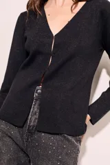 Cardigan de lurex color camel, con calce al cuerpo y cierre frontal, de manga larga y material ligero.