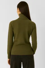 Polera de tejido acrílico color marrón, de manga larga y cuello tortuga.