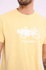 Remera mostaza de algodón con cuello redondo y estampado de una bicicleta con tablas de surf y el texto "Live Simply".