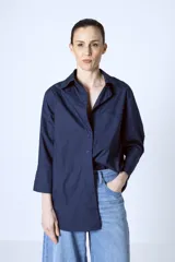 Camisa azul marino de corte holgado, con cuello clásico, cierre frontal con botones y mangas 3/4.