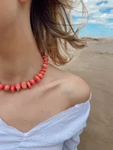 Gargantilla con piedras naturales rosas y cuentas doradas.