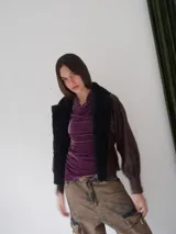 Campera de cuero vacuno color marrón con solapa de corderito negro y costuras a mano.
