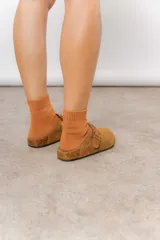 Zuecos de cuero color beige, con diseño clásico y hebilla regulable. Cuentan con plantilla anatómica y suela de corcho.