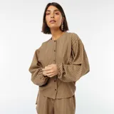 Blusa marrón con rayas verticales negras, corte oversize, cuello redondo y mangas largas abullonadas.