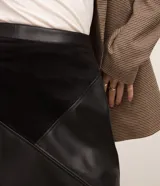 Minifalda negra de cuero con paneles geométricos de gamuza.