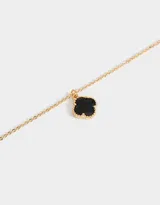 Cadena corta dorada con dije de trébol negro con borde dorado.