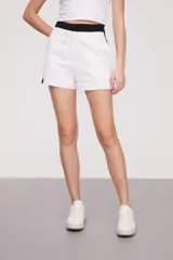 Short de lino blanco con cintura alta negra y corte recto.