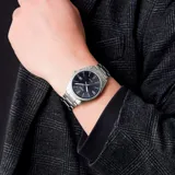Reloj Casio analógico para hombre, modelo MTP1302D-1A1VDF, con caja y brazalete de acero inoxidable color plateado, esfera negra con indicadores plateados y función de calendario. Resistente al agua hasta 50 metros.