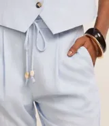 Pantalón fluido color verde oliva confeccionado en viscolino, con cintura elástica, lazo, pliegues y bolsillos.