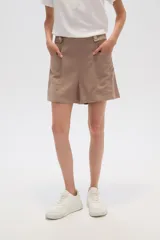 Short color beige de lino, de calce alto y holgado, con bolsillos laterales y detalle de botones decorativos en la cintura.