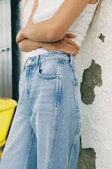 Pantalón de jean celeste de tiro medio y corte wide leg, con cinco bolsillos y costuras laterales marcadas.
