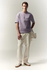 Remera lila de algodón pesado, corte holgado, con cuello redondo ribeteado y hombros caídos.