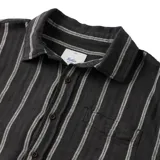 Camisa de manga corta negra con rayas verticales blancas, cuello clásico y bolsillo en el pecho.