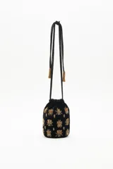Cartera tipo bombonera negra de terciopelo con bordado de lentejuelas y canutillos dorados con forma de insectos. Tiene cordón de ajuste con borlas de canutillos dorados y correa de mano.