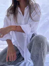 Camisa blanca de manga larga, corte oversize y cuello camisero.