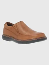 Zapato de vestir color marrón, sin cordones, de cuero vacuno liso. Tiene elásticos laterales, plantilla de cuero y algodón orgánico, y suela de goma EVA.