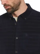 Camisa de corderoy azul marino con rayas horizontales en relieve, corte slim fit, cuello abotonado, manga larga y bolsillo plaqué en el pecho.