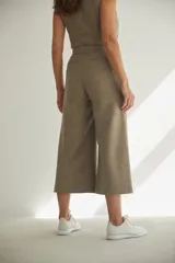 Pantalón capri color marrón claro, de corte palazzo y tiro alto. Confeccionado en tejido tweed.