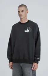 Buzo negro de frisa 100% algodón, de calce oversize y cuello redondo. Estampado pequeño en el frente del personaje Mickey Mouse enojado.
