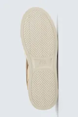 Zapatillas deportivas de estilo retro, color beige y marrón, con cordones y suela gruesa.