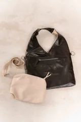 Bolso hobo reversible color azul marino, con textura símil cuero y correa bandolera extraíble.