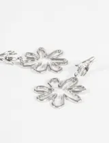 Aros colgantes plateados con forma de flor y gancho con forma de mano.