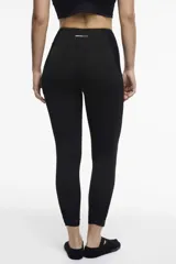 Calza deportiva larga negra con cintura alta, detalles de transparencias laterales en tul y bolsillos laterales.