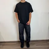 Jean de hombre color negro con efecto lavado, de corte mom fit, con cintura elástica y puños ajustados en los tobillos.