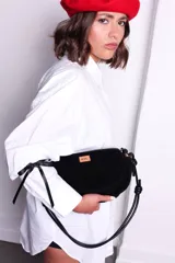 Cartera tipo sobre color bordó, confeccionada en PU tipo gamuza, con correa regulable de nudos chunky y cierre superior.