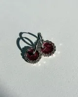 Par de aros colgantes con argolla de acero quirúrgico, dije circular de resina negra y borde de strass plateado.